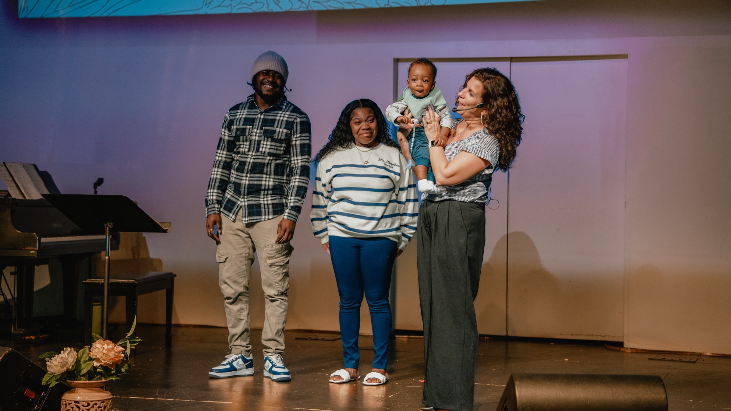 A family on stage with a pastor during a Parent Child Dedication